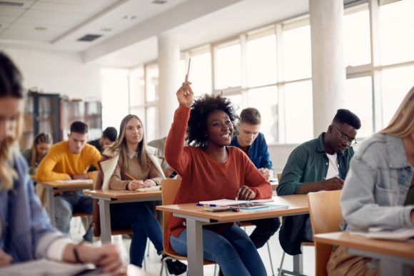 A female student raises her hand in class