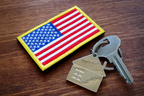 A key with a house keychain and American flag.