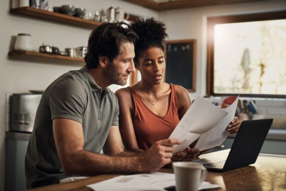 A married couple uses a laptop to choose the best Tricare plan during Tricare Open Season.